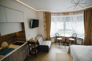 a bedroom with a bed and a kitchen and a table at VIP Studio on E. Polotskoy 5 in Minsk