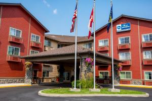 una vista frontal de un hotel con banderas americanas en Best Western Rocky Mountain Lodge, en Whitefish