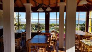 un comedor con mesas, sillas y ventanas en South B&B El Calafate en El Calafate