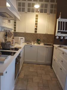 cocina con armarios blancos y suelo de baldosa en sweet home en Biella