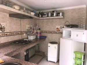 a kitchen with a white refrigerator and a stove at appartement traditionnel et contemporain, au coeur du kasbah in Tangier