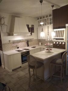 cocina con armarios blancos, mesa y sillas en sweet home en Biella