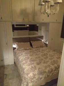 1 dormitorio con 1 cama con armarios blancos en sweet home en Biella
