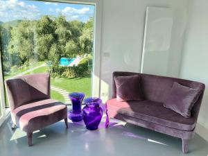 two chairs and a couch in a room with a window at Villa Il Bacio del Sole in Verona