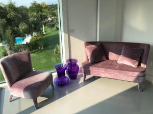 2 sedie e un divano in una stanza con finestra di Villa Il Bacio del Sole a Verona