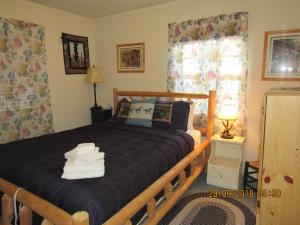a bedroom with a wooden bed with towels on it at Apple Bear Cabin in Big Bear City
