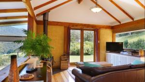 a living room with a couch and a tv at Shanleys Huon Valley in Glendevie