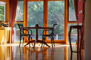 a table and chairs in a room with a window at Shanleys Huon Valley in Glendevie