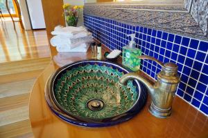 a bathroom sink with a green glass bowl at Shanleys Huon Valley in Glendevie