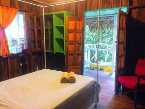 a bedroom with a bed with two shoes on it at Madre Selva Hostel in Puerto Viejo