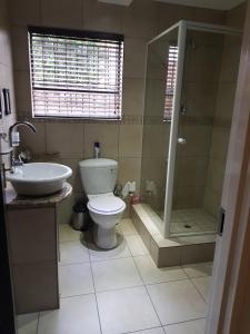 a bathroom with a toilet a sink and a shower at Villa Xanelle Boutique Guest House in Centurion