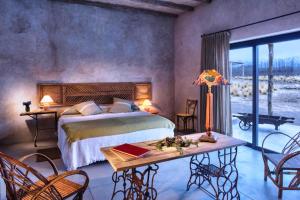 a bedroom with a bed and a table and chairs at Lodge Atamisque in San José