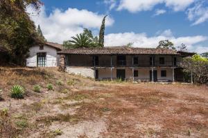 una casa vieja al lado de una colina en Hacienda Gonzabal en Loja