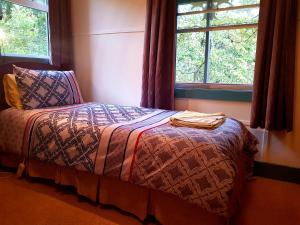 A bed or beds in a room at Glenbrook House & Cottage