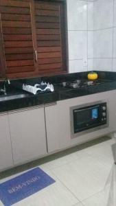 um balcão de cozinha com um fogão e um micro-ondas em Cond. Águas da Serra, Bananeiras em Bananeiras