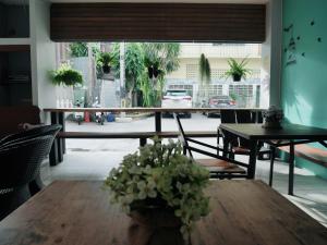 a room with a table and chairs and a window at Pakchong Phubade Hotel in Pak Chong