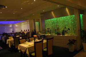 a dining room with tables and a green wall at Ababeel Hotel in Birmingham