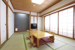 a dining room with a table and chairs and windows at Osaka Garden Palace in Osaka