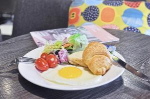 a plate of food with an egg and vegetables on a table at Kindness Hotel - Zhongshan Bade Branch in Kaohsiung