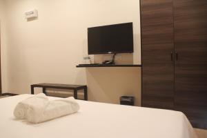a hotel room with a bed with a towel on it at Gergasi Inn in Ipoh