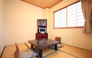 sala de estar con mesa y microondas en Hotel Bouenkaku, en Tome