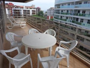 - Balcón con mesa blanca y sillas en Sinta-se em casa na praia do Forte, en Cabo Frío