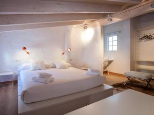 a bedroom with a white bed with lights on it at Cheap & Chic Hotel in Ciutadella