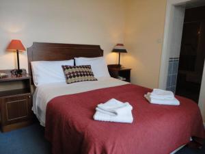 um quarto de hotel com uma cama com toalhas em Alpine Guesthouse em Dingle