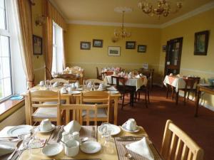 uma sala de jantar com mesas e cadeiras num restaurante em Alpine Guesthouse em Dingle