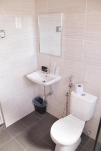 a bathroom with a white toilet and a sink at Gergasi Inn in Ipoh