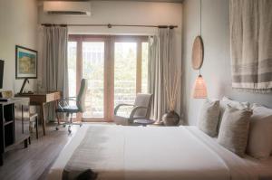 a bedroom with a bed and a desk and a window at iRoHa Garden Hotel & Resort in Phnom Penh