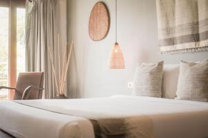 a white bedroom with a bed and a window at iRoHa Garden Hotel & Resort in Phnom Penh