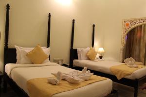 two beds in a hotel room with towels on them at Sanchal Fort in Bārmer