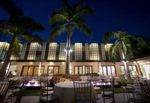 uma mesa e cadeiras em frente a um edifício com palmeiras em Sugarland Hotel em Bacolod