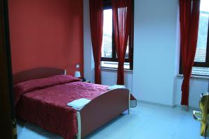 a bedroom with a bed with red walls and windows at Albergo Ma.Re in Popoli