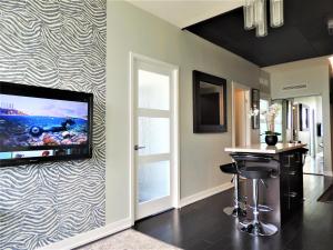 a living room with a flat screen tv on a wall at TVHR - Luxury Condos in Heart of Downtown in Toronto
