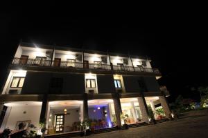 a lit up building with a balcony at night at Kalton Hotel in Labuan Bajo
