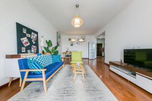 西安市にあるXi’an NewTown·North Passenger Station· Locals Apartment 00125860の青いソファとテレビのあるリビングルーム