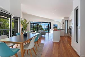 a dining room and living room with a table and chairs at Barefoot Bungalow - Castaways Beach in Sunrise Beach