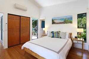 サンライズ・ビーチにあるBarefoot Bungalow - Castaways Beachの大きな白いベッドと窓のある寝室 +14枚の写真