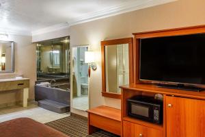 a hotel room with a television and a bathroom at Motel 6-Alvin, TX in Alvin