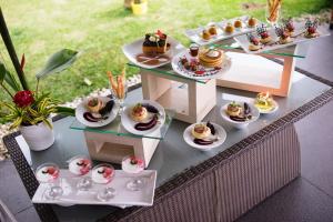 a table topped with plates of desserts on a table at Lembang Asri Resort in Lembang