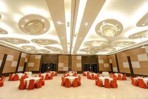 a large banquet hall with tables and orange chairs at Lembang Asri Resort in Lembang