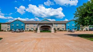 a large blue building with cars parked in a parking lot at Best Western Atoka Inn & Suites in Atoka