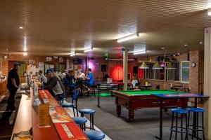 a large room with tables and chairs and a bar at Gascoyne Hotel in Carnarvon