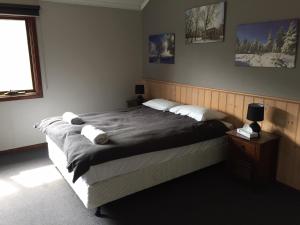 a bedroom with a large bed and a window at Winterhaus Lodge Thredbo Village in Thredbo