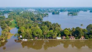 an island in the middle of a river with houses at Warmth Lake Haven in Alleppey