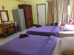 três camas num quarto com lençóis roxos em Peamsuk Sweet Prachin Buri em Prachin Buri