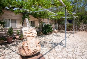 een standbeeld van een vrouw die onder een boom zit bij Kibbutz Inbar Country Lodging in Kibbutz Inbar