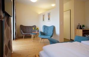 a bedroom with two blue chairs and a table at Nachtquartier Zur Dankbarkeit in Podersdorf am See